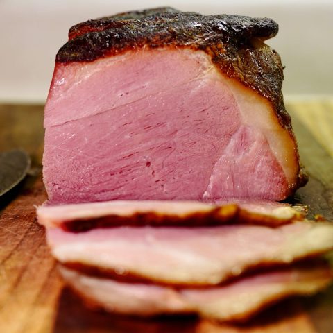 ham on a board, slices lay in front