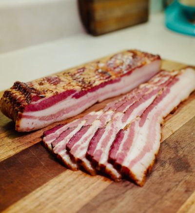 raw bacon on wooden board