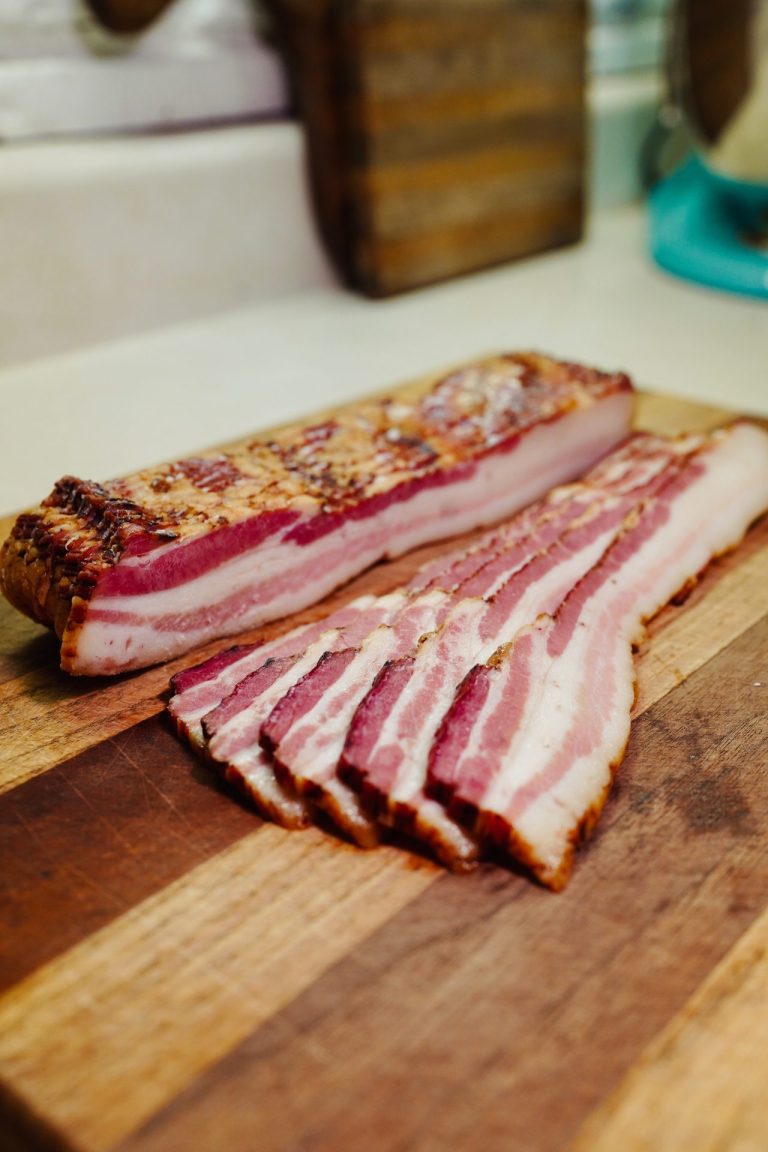 raw bacon on wooden board