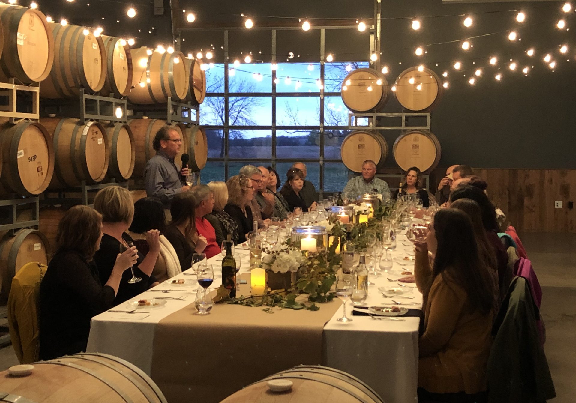 dinner party in a winery surrounded by wine barrels