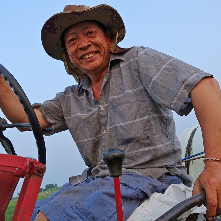 farmer smiling from a red tractor
