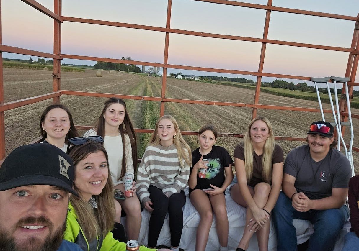 A family having fun on a hay wagon.