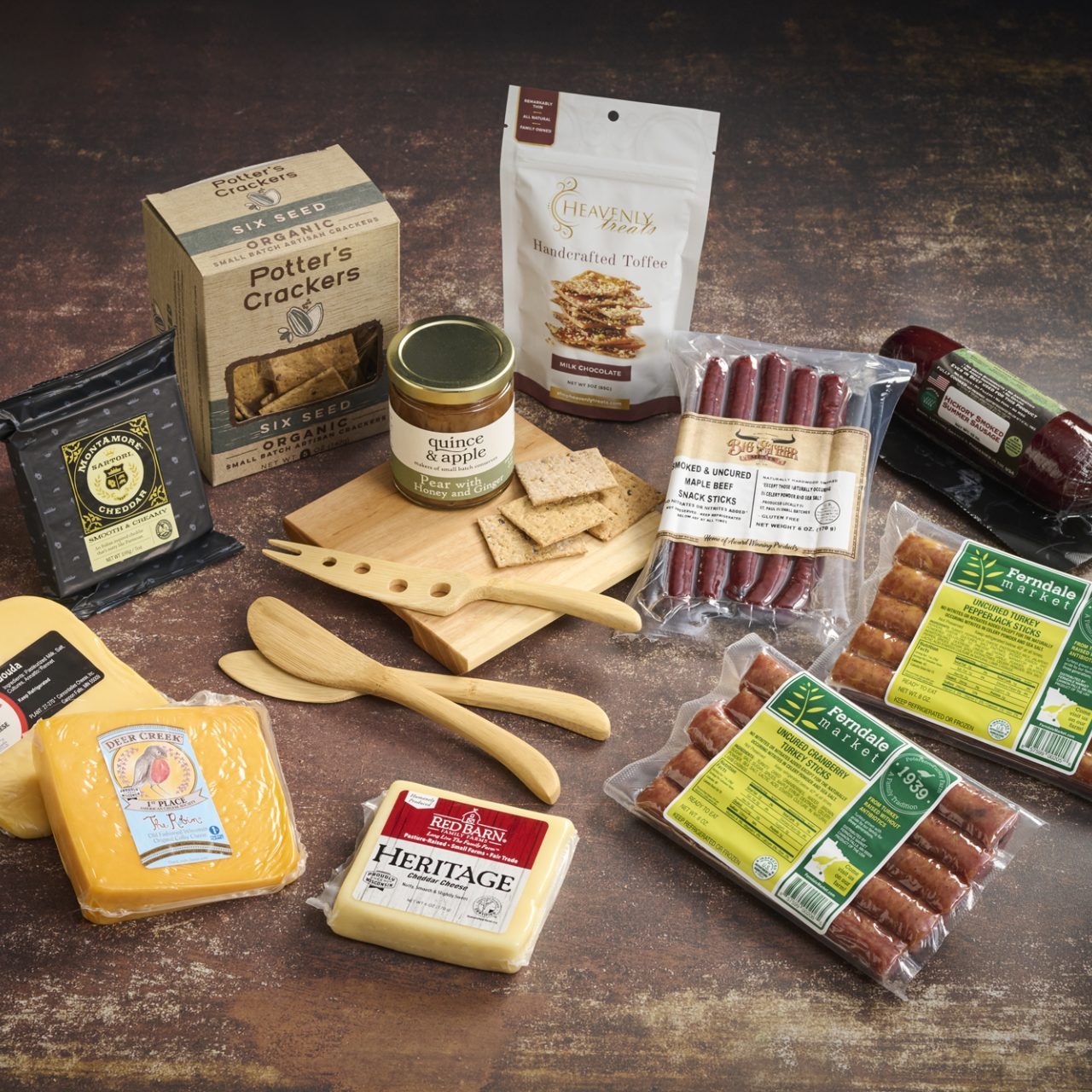 spread of cheese, meat, and other goods on wooden table