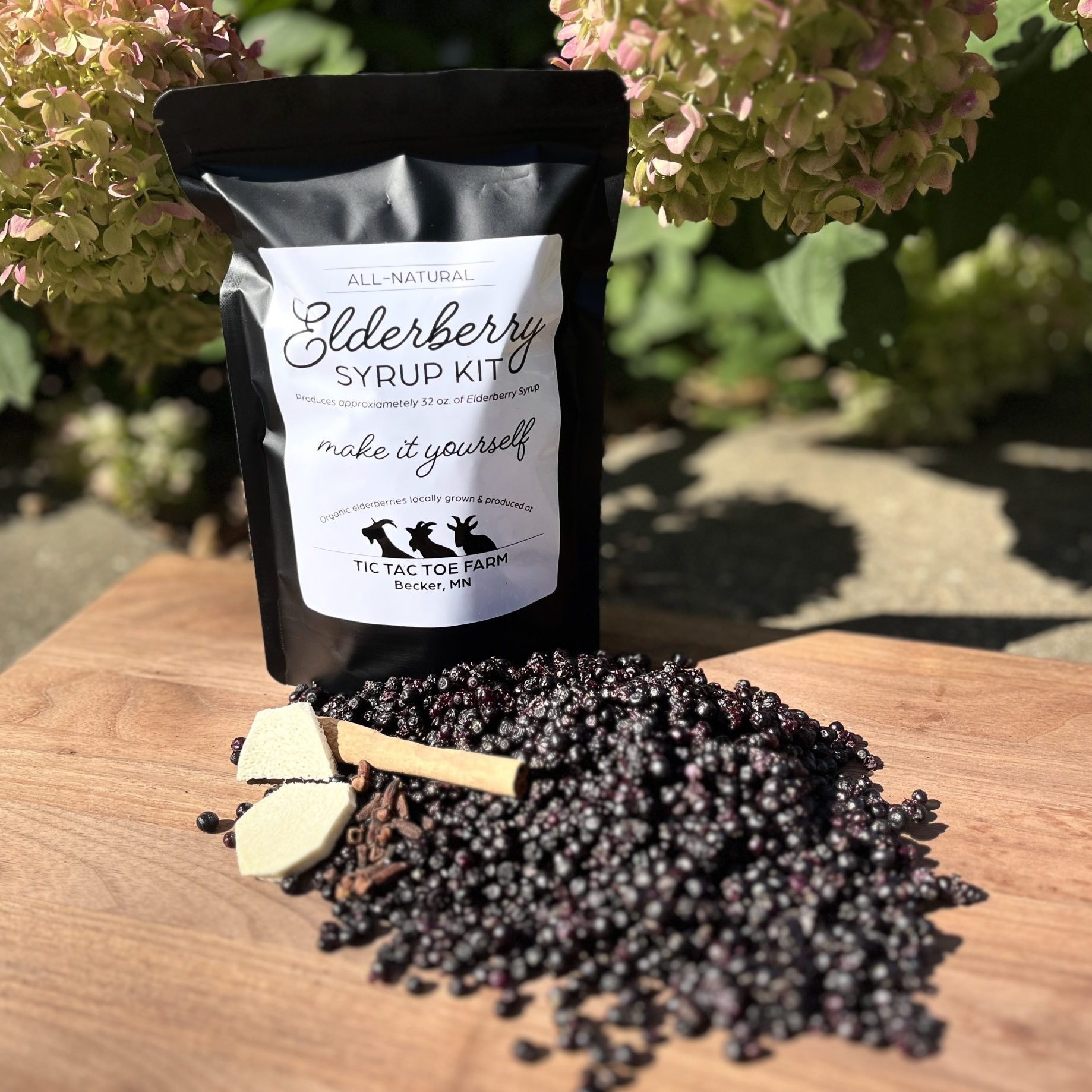 black bag with pile of small, dark berries on a wooden table