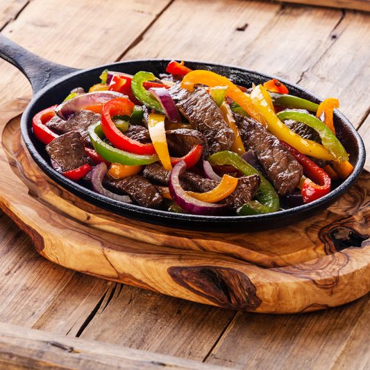 Beef Fajitas with colorful bell peppers in cast iron pan